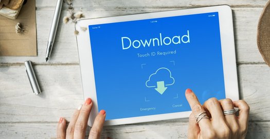 Die Finger einer Frau tippen auf dem Tablet auf das Wort "Download"