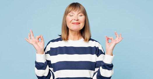Frau in blau-weiß gestreiftem Pullover mit meditativer Handhaltung (Daumen und Zeigefinger berühren sich)