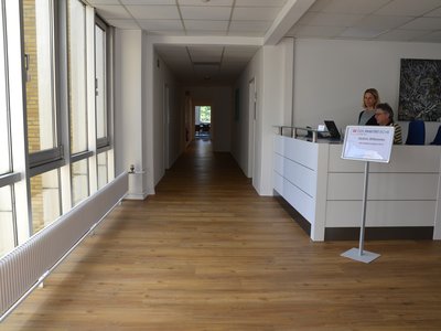 Ein langer Flur mit dem Empfang auf der rechten Seite - der Eingangsbereich in der Schloßstraße