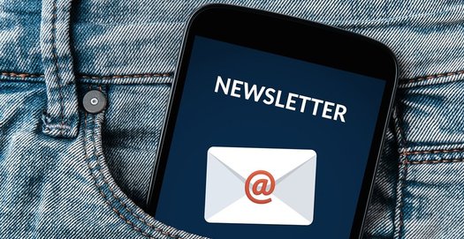 Aus einer Hostentasche schaut ein Handy heraus, auf dem jemand gerade eine Benachrichtigung über den Eingang eines Newsletter bekommen hat
