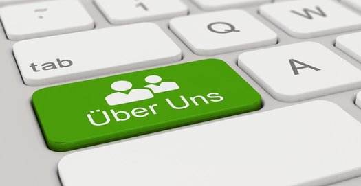 Auf einer Tastatur ist die Taste "Über uns" zu sehen